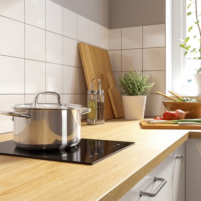 Black induction hob with glass surface, single heating zone, touch control panel, and safety lock key.