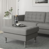 Modern living room with a grey LANDSKRONA seat & ottoman. Leather & fabric, square cushions. Ottoman holds tray, bowls, & glasses. Matches sofas size.