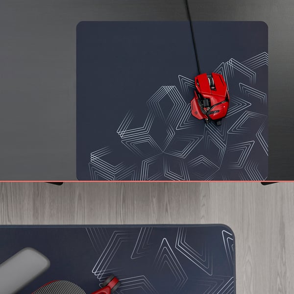 Dark gaming desk with dark mouse pad featuring a geometric pattern. A red gaming mouse with a cord lies on the pad, ready for use.