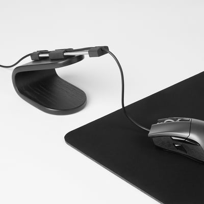 Black gaming mouse bungee keeps cord orderly, allowing full freedom of movement. Mousepad and wired gaming mouse shown.