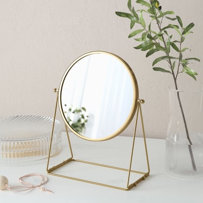 Gold-framed table mirror with a 3x magnifying side. Elegant home decor item.