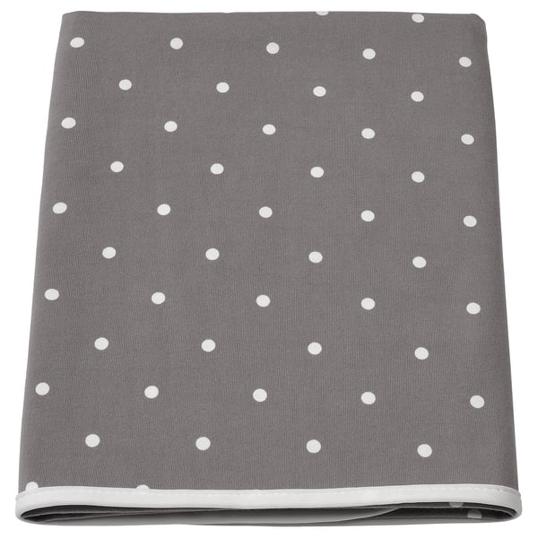 A gray and white polka-dotted babycare mat with a polyester edging and cotton fabric.