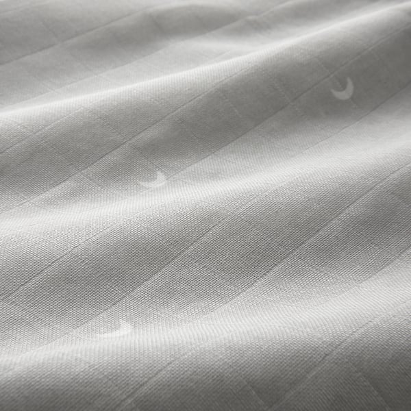 Soft, wrinkled muslin fabric close-up, showcasing its smooth texture and quality.