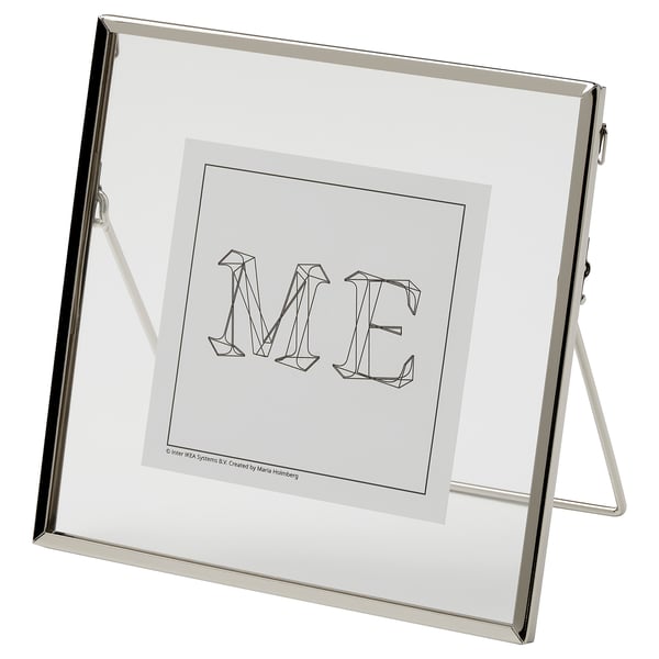 A LERBODA frame, silver, standing with a modern design displaying the letters me.