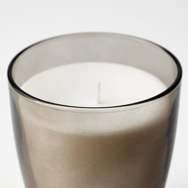 Close-up of a well-crafted scented candle in frosted glass with a visible wick.