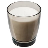 A LINDLÖNNSKOG candle in a frosted glass jar. The candle is white with a vanilla scent. The jar has a slightly irregular shape and a greyish tint.