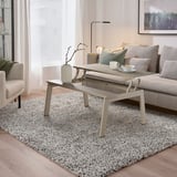 Living room with LJUNGSBRO table, sofa, chair, lamp, art, rug, curtains.