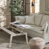 Modern living room with a versatile coffee table that converts into a dining table or desk, featuring a raised tabletop for laptop use.