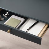 Open desk drawer with notebooks, pencil, and handle.