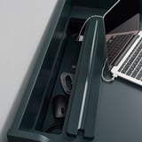 Desk with hidden drawer, storing cords and mouse. Laptop on right, with cable management visible.