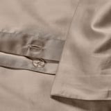 Duvet cover with button closure, smooth texture, and elegant grey-beige color.