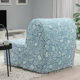 Blue patterned chair with white lines, sitting on rug, next to round table with cup. Converts to bed.