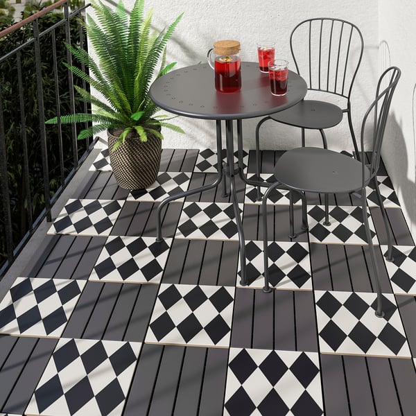 Checkered MÄLLSTEN tiles on small balcony with table, chairs, and plant.