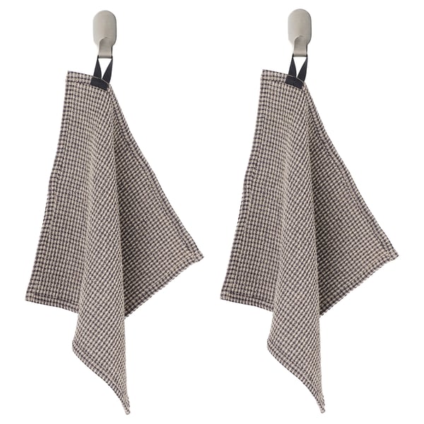Two houndstooth kitchen towels hang from metal hooks, black loops at top, beige and black checkered pattern.