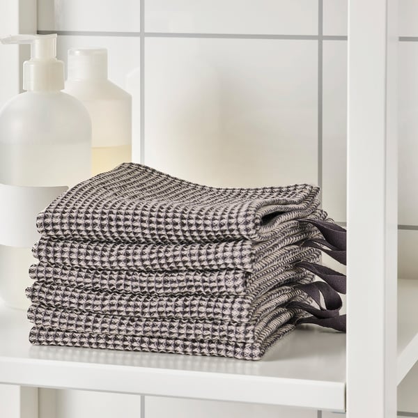 Folded towels on a white shelf, featuring a geometric pattern, suitable for high absorption.