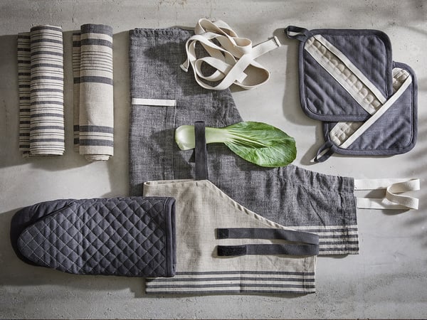 Kitchen accessories: oven mitts, towels, potholders in grey/beige, linen/cotton with striped/diamond patterns.