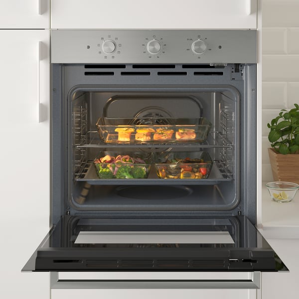 Open oven with food trays inside. Self-clean and convection functions.