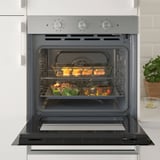 Open oven with food trays inside. Self-clean and convection functions.