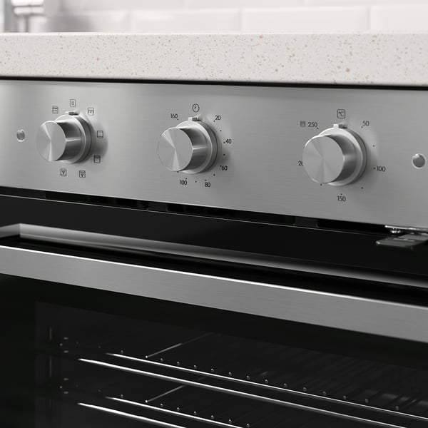 Modern oven with sleek metallic knobs and digital controls. Displays temperature and cooking settings, suitable for various kitchen tasks.
