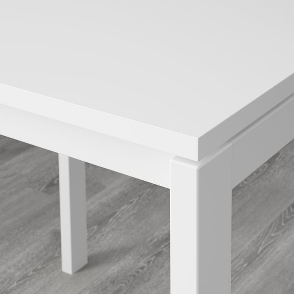Close-up of durable, white MELLTORP table corner on stylish wood floor.