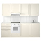 Minimalist white kitchen setup with cream cabinets, sink, and oven. Bright and modern design, ideal for small spaces.