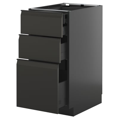 Modern black kitchen cabinet with three open drawers, sleek handles, and a glossy finish.