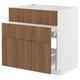 A METOD kitchen cabinet with a white frame and walnut-colored wooden drawers. It has three drawers with a sleek, modern design.