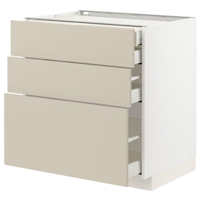 A white ikea METOD cabinet with three beige drawers. The cabinet has a smooth, clean design with self-closing drawers.