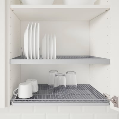A kitchen cabinet with adjustable shelves storing white plates and cups.