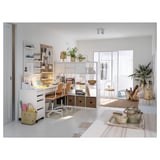 Bright, white home office with white MICKE desk and storage units. Holds baskets, plants, and a computer. Natural light fills the room.