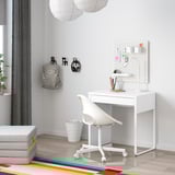 MICKE desk setup in bright room, simple modern design with drawer, chair, organizer, and wall-mounted accessories.