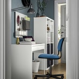 Home office setup with white micke desk, blue örfjäll chair, and kallax shelf, neatly organized.
