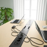 Modern office table with built-in power sockets, neatly organized with laptops, a plant, and a mug.