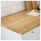 This image shows a wooden kitchen countertop, part of the MÖLLEKULLA series. Its light brown surface is evenly textured, supported by white cabinetry.