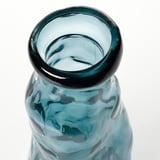 Clear glass vase with blue tint, textured surface, smooth edges.