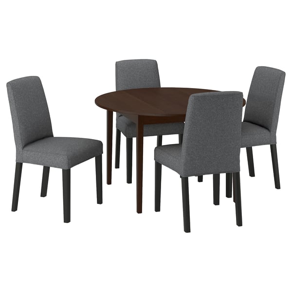 Dark wood round dining table with four grey fabric chairs, sleek design, great for small spaces.