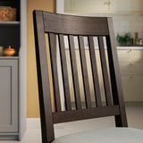 Wooden dining chair with slatted back, dark finish. Upholstered seat, quality crafted, fits modern or rustic decor.