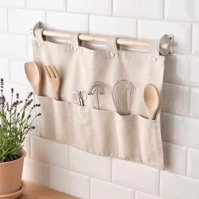 Kitchen organizer NEREBY hangs on rail, holding wooden utensils in separate pockets, keeping them accessible and tidy.