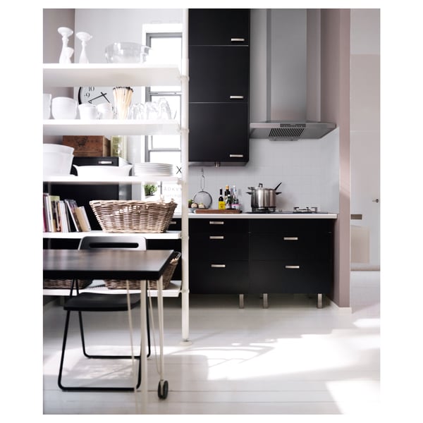 Modern kitchen with black cabinets, stainless steel appliances, open shelving, and a cozy reading nook.