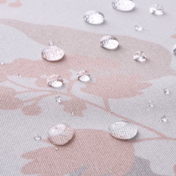 Close-up of a water-repellent tablecloth with beads of water on a leaf pattern.