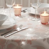 Floral tablecloth, candles, wine glasses, cutlery - cozy setting.