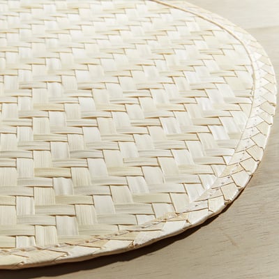 Handwoven pentagonal place mat in natural color from palm leaf, showcasing a smooth, decorative pattern.