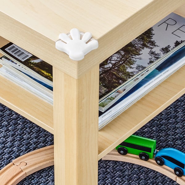 Wooden table with white corner bumper, protecting kids from sharp edges.