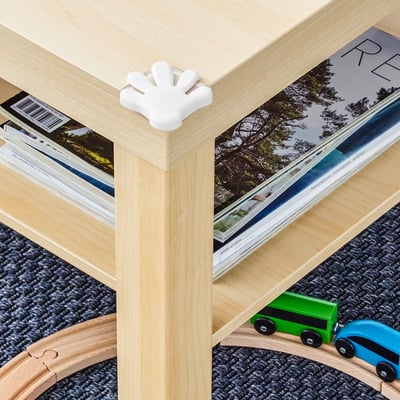 Wooden table with white corner bumper, protecting kids from sharp edges.