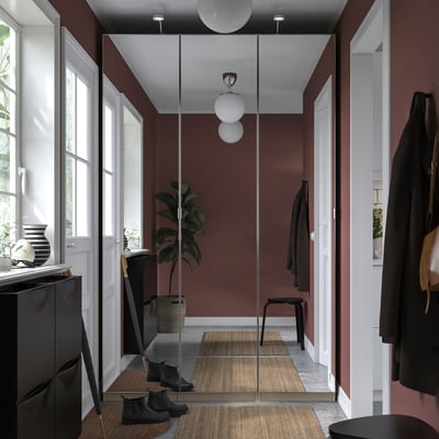 Modern hallway with maroon PAX wardrobe, mirrored doors, hanging coats, and boots.