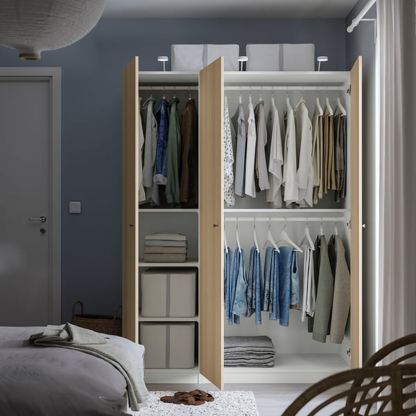Open wardrobe showing clothes, folded items, and storage bins, featuring adjustable interiors and slow-closing doors.