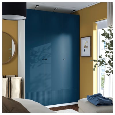 Teal PAX wardrobe in room, glossy finish, plant by window.