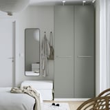 Modern bedroom with grey PAX wardrobe, bench, mirror, and bedside lamp.