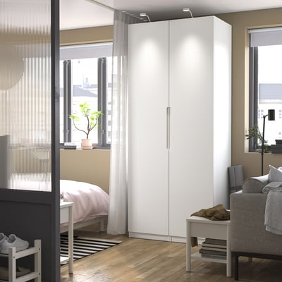 Modern white PAX wardrobe in bright, cosy bedroom.