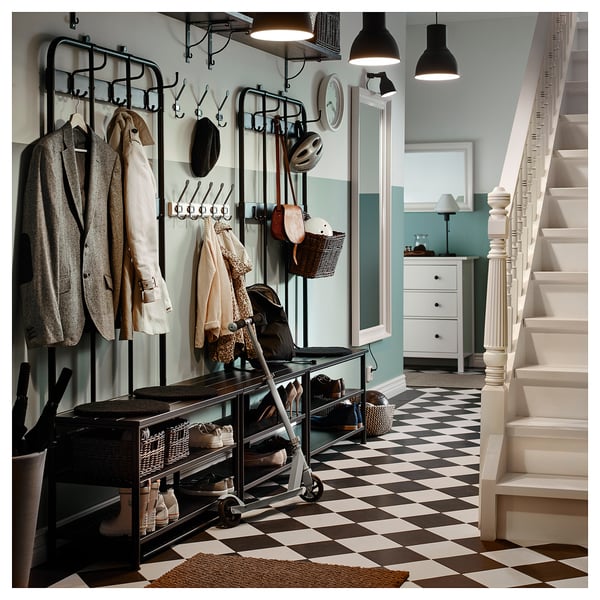 Coat rack, shoe storage, bench, grey checked floor, helmets, baskets.